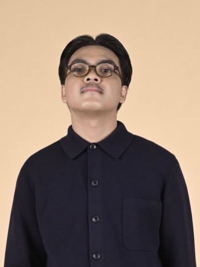 Portrait of Edwin Jr. P. Bayog against a warm sand backdrop
